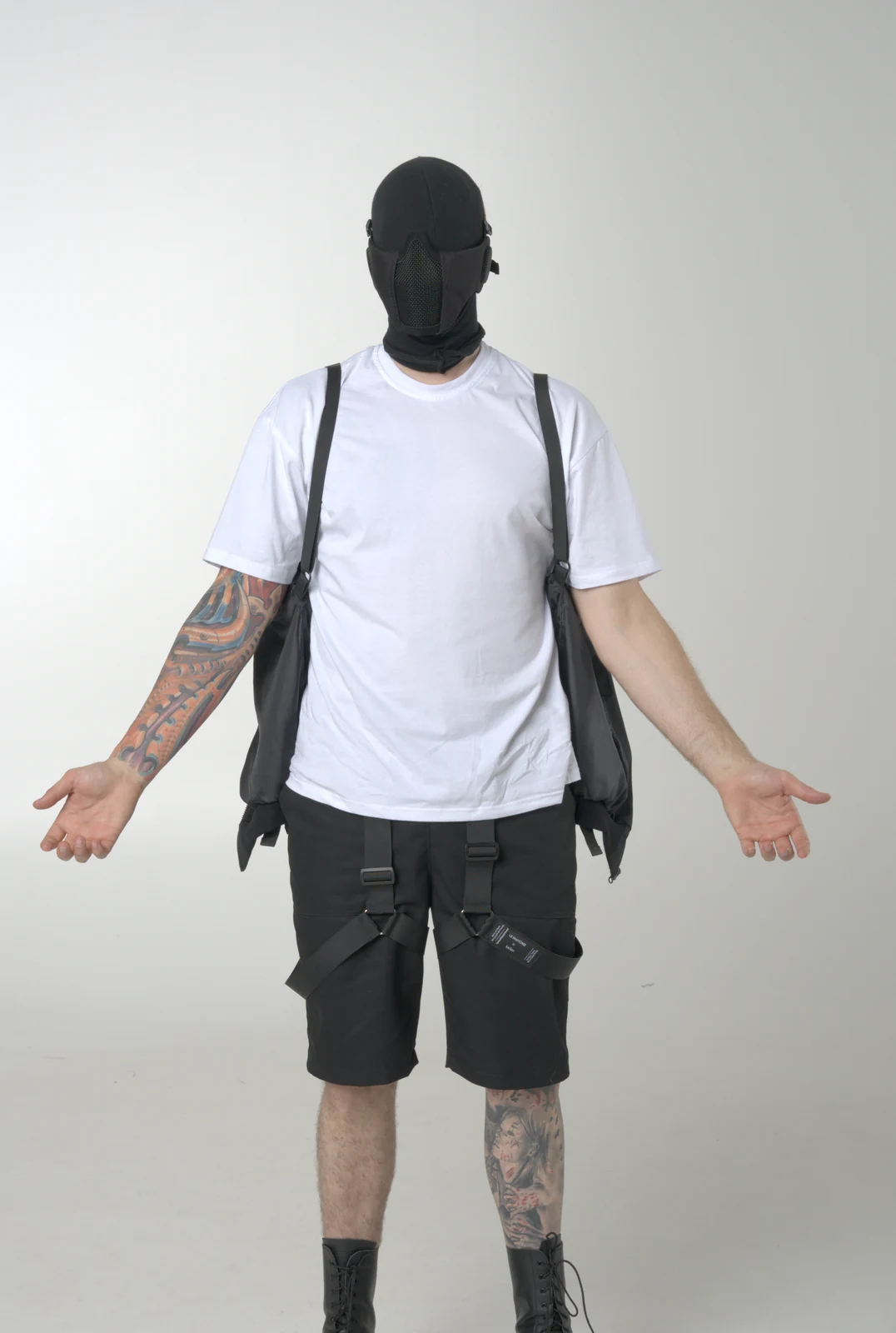 An LF black jacket carried behind the body on internal shoulder straps, over a white T-shirt and cargo shorts