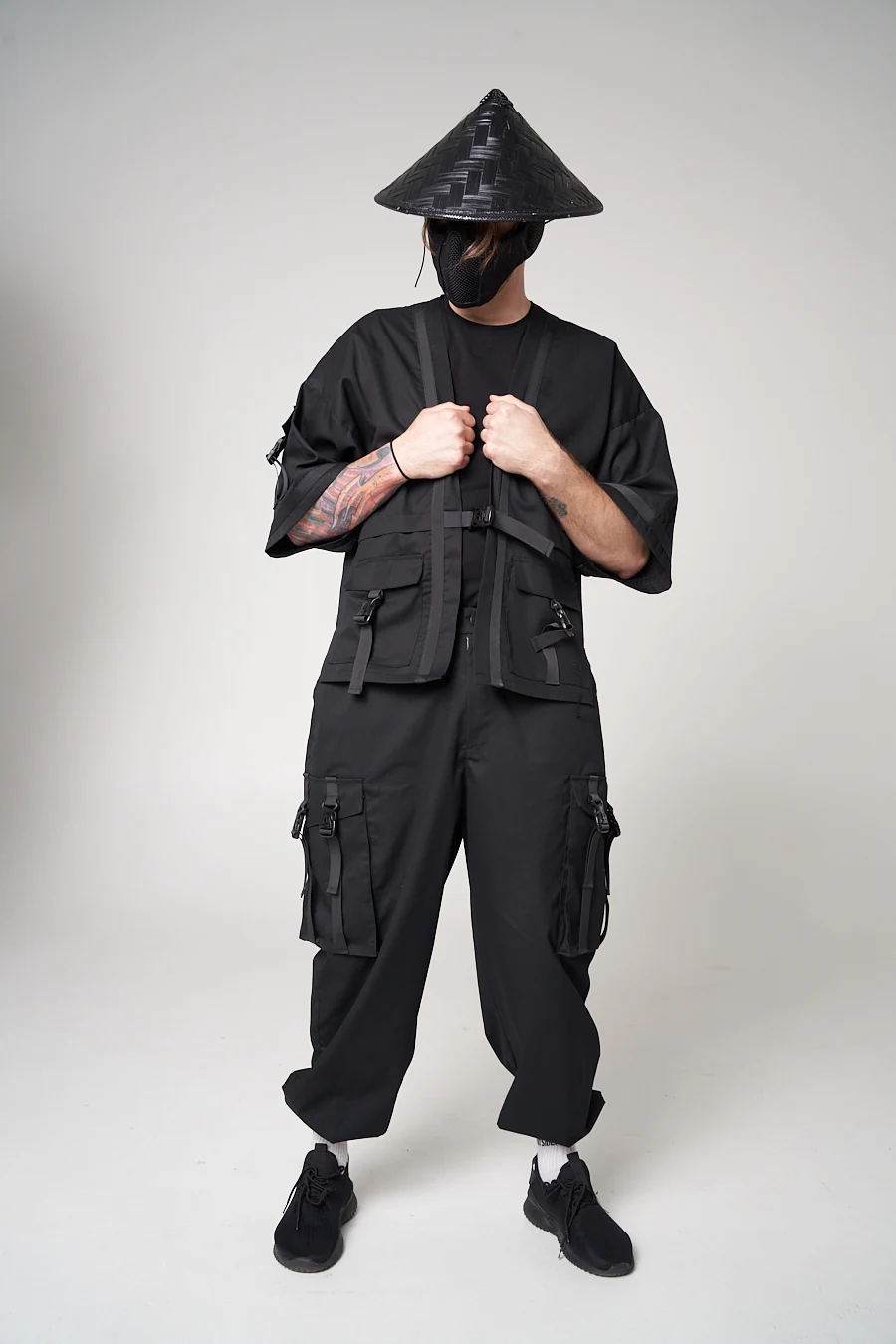 An LF black wide-sleeved outer layer with front pockets and a buckle, styled over loose cargo trousers